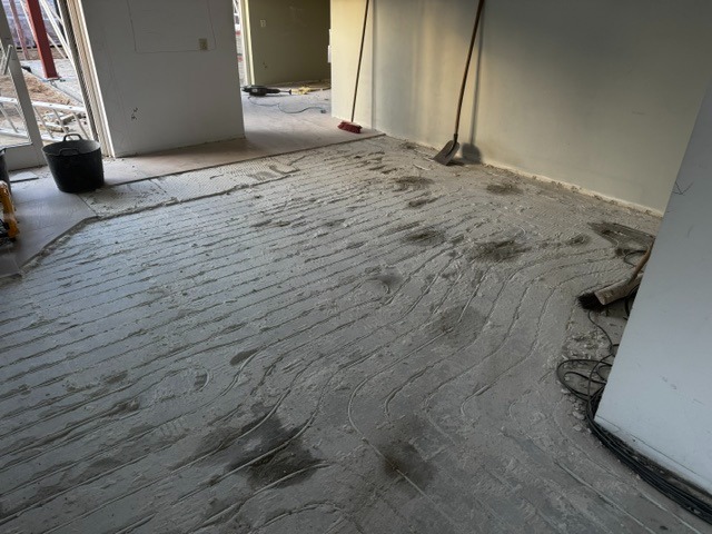 Gefreesde slingersleuven in een betonvloer voor het aanbrengen van vloerverwarming
